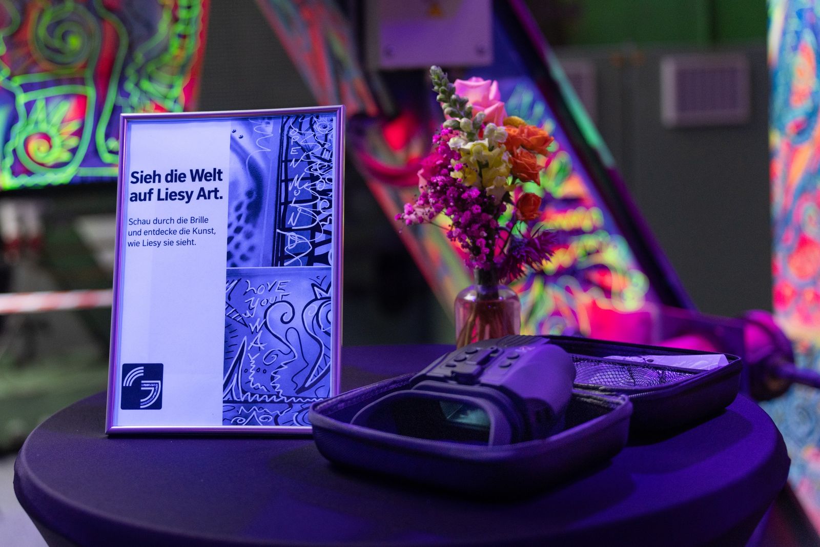 VR-Brille und Infotafel zu Liesy Art auf einem Stehtisch