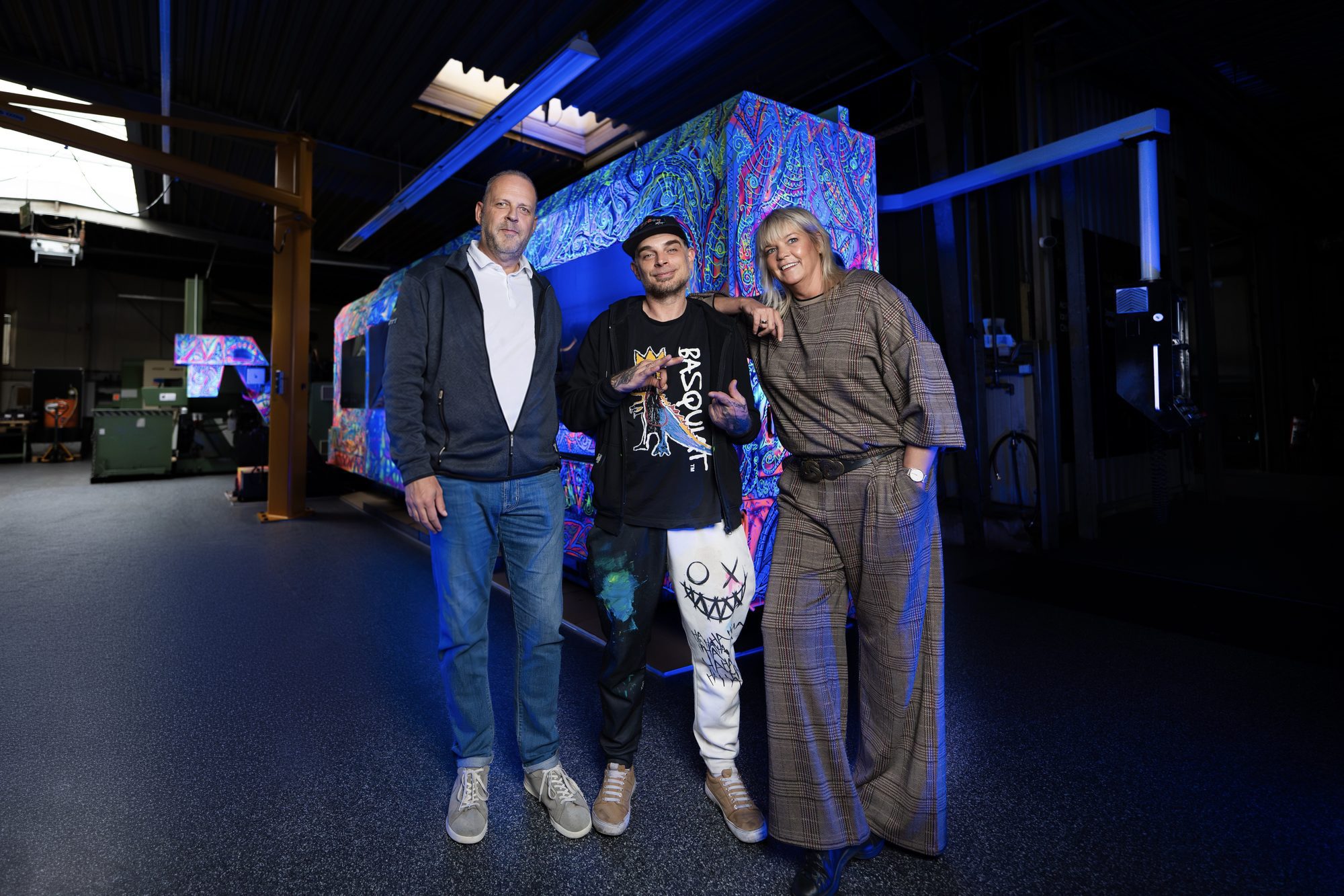 Sven Liesy mit Petra und J&ouml;rg Schneider vor der unter Schwarzlicht leuchtenden Sachman T10