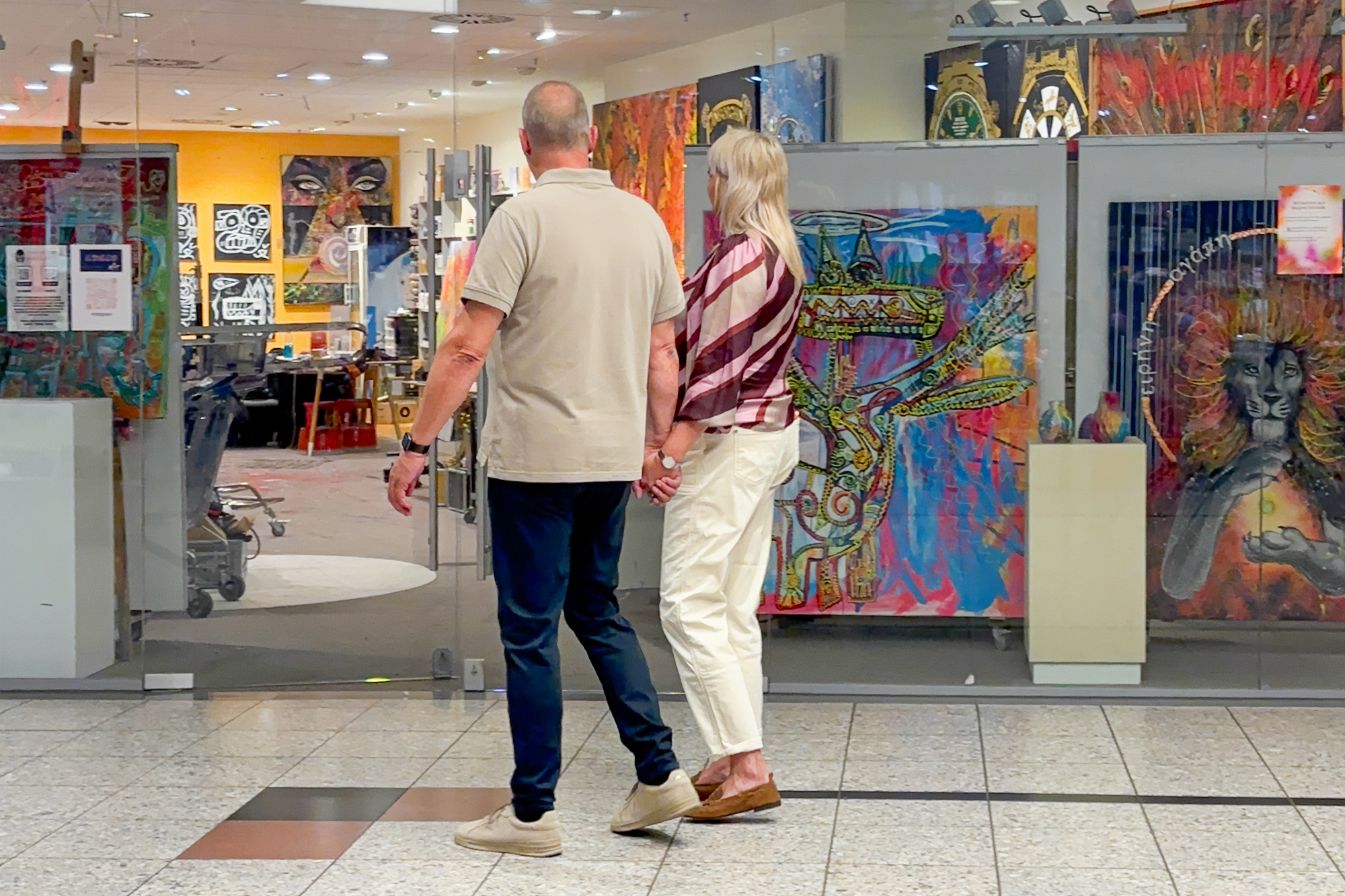 Petra und J&ouml;rg Schneider betrachten im Atelier die Werke von Sven Liesy